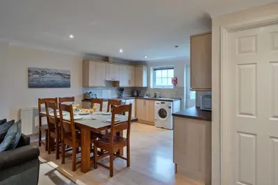 a kitchen and dining room with a table and chairs at Finest Retreats - Atlantic 55 in Newquay