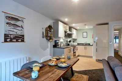a kitchen and dining room with a wooden table at Finest Retreats - Pobbles Place in Fowey
