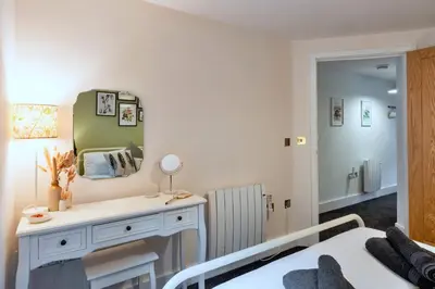 a bedroom with a bed and a mirror at Finest Retreats - Pobbles Place in Fowey