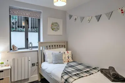 a small bedroom with a bed and a window at Finest Retreats - Pobbles Place in Fowey