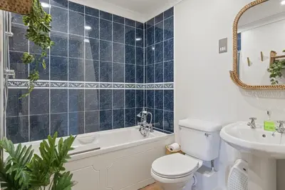 a bathroom with a toilet and a tub and a sink at Apartment Sea Views & Parking Walk to Fistral in Newquay