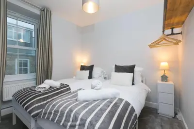 two twin beds in a bedroom with a window at Dan's Den in St Ives