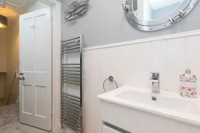 a bathroom with a sink and a mirror at Dan's Den in St Ives