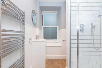 a white bathroom with a sink and a window at Dan's Den in St Ives