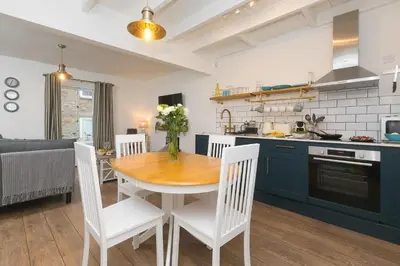 a kitchen and dining room with a wooden table and chairs at Dan's Den in St Ives