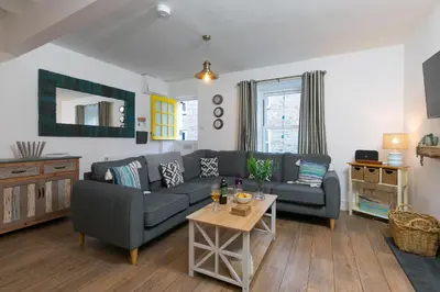a living room with a couch and a table at Dan's Den in St Ives
