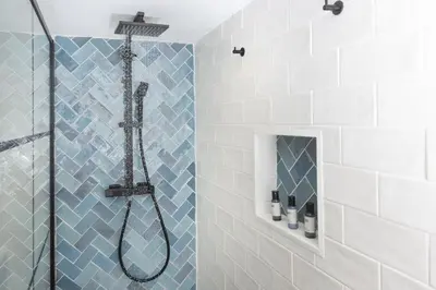 a bathroom with a shower with blue and white tiles at Happy Days Cottage - Free WiFi - Minutes from Harbour & Beaches - Pets Welcome in St Ives