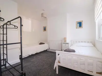 a bedroom with two beds and a ladder in it at Trevarthian in St Austell