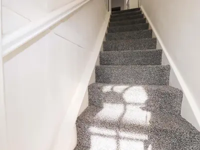 a staircase with a shadow of a person on the stairs at Trevarthian in St Austell