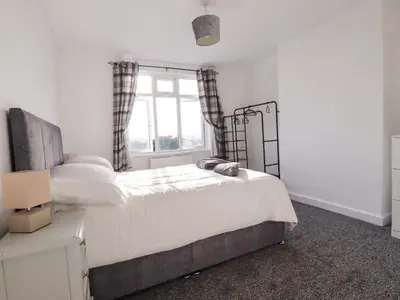 a bedroom with a large bed and a window at Trevarthian in St Austell