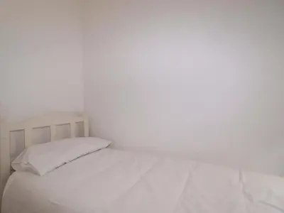 a white bed with white sheets and pillows at Trevarthian in St Austell
