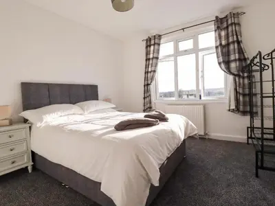 a bedroom with a large bed and a window at Trevarthian in St Austell
