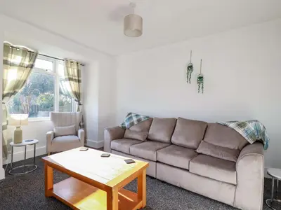 a living room with a couch and a table at Trevarthian in St Austell