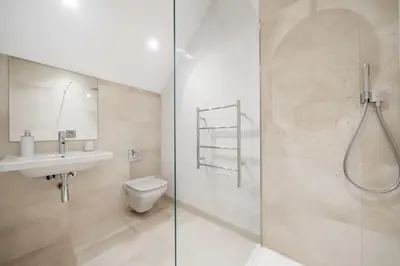a bathroom with a shower and a toilet and a sink at Modern Home with Stunning Gannel Estuary Views in Newquay