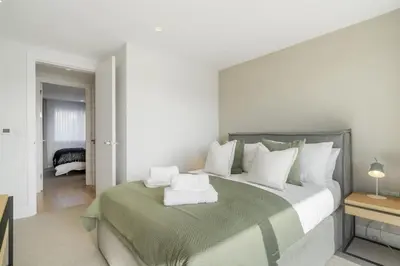 a bedroom with a large bed with white pillows at Modern Home with Stunning Gannel Estuary Views in Newquay