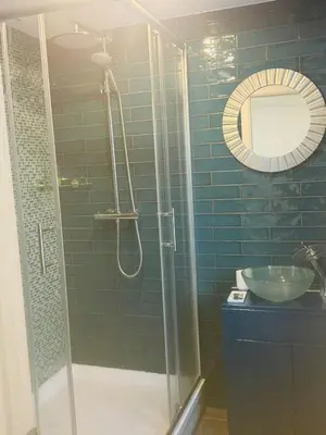 a bathroom with a shower with a sink and a mirror at Dancenter Tolcarne Beach hotel in Newquay