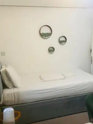 a bed with two mirrors on a white wall at Dancenter Tolcarne Beach hotel in Newquay