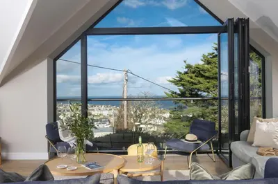 a living room with a large window with a view of the eiffel tower at Cloud 10, St Ives - Free WiFi - Free Parking - Pets Welcome - Sea Views in St Ives