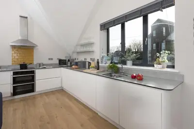 a kitchen with white cabinets and a sink at Cloud 10, St Ives - Free WiFi - Free Parking - Pets Welcome - Sea Views in St Ives