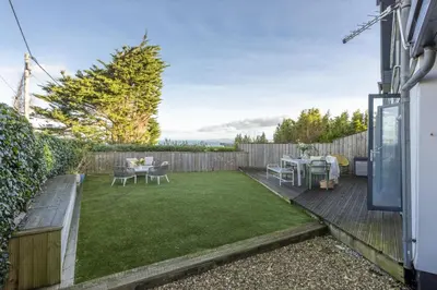 a small backyard with a dining table and grass at Cloud 10, St Ives - Free WiFi - Free Parking - Pets Welcome - Sea Views in St Ives