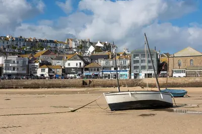a boat sitting on the sand on the beach at Cloud 10, St Ives - Free WiFi - Free Parking - Pets Welcome - Sea Views in St Ives