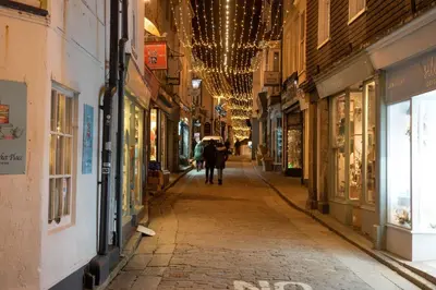 a person walking down a street with an umbrella at Cloud 10, St Ives - Free WiFi - Free Parking - Pets Welcome - Sea Views in St Ives