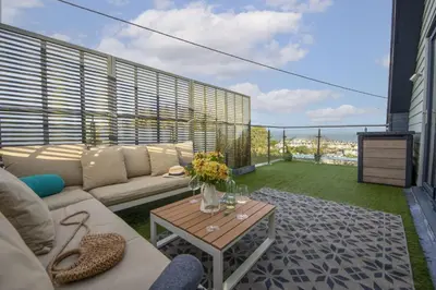 a living room with a couch and a table on a balcony at Cloud 10, St Ives - Free WiFi - Free Parking - Pets Welcome - Sea Views in St Ives
