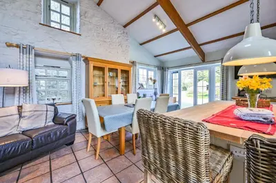 a kitchen and dining room with a table and chairs at The Old Farmhouse in Looe
