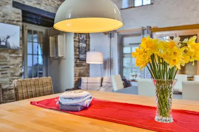 a vase of yellow flowers sitting on a table at The Old Farmhouse in Looe