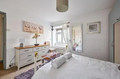 a bedroom with a bed and a dresser and a mirror at The Old Farmhouse in Looe