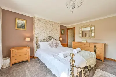 a bedroom with a large bed and a mirror at The Old Farmhouse in Looe