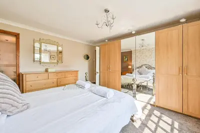a bedroom with a large bed and a mirror at The Old Farmhouse in Looe