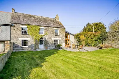 an old stone house with a large yard at The Old Farmhouse in Looe