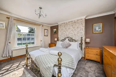 a bedroom with a bed and a window at The Old Farmhouse in Looe