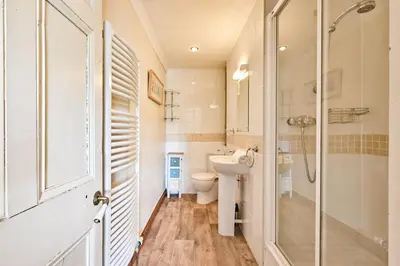 a bathroom with a toilet and a shower and a sink at The Old Farmhouse in Looe