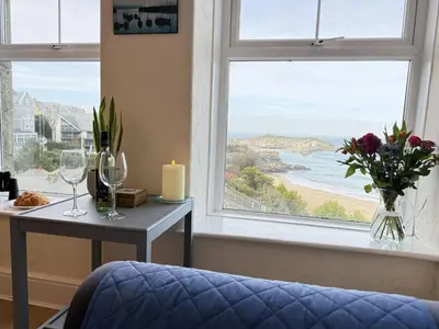 a room with a table and a window with a view of a beach at Draycott Dreams in St Ives