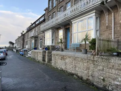 a row of buildings on a street with cars parked outside at Draycott Dreams in St Ives