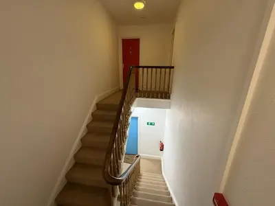 a stairway with a red door and a red door at Draycott Dreams in St Ives