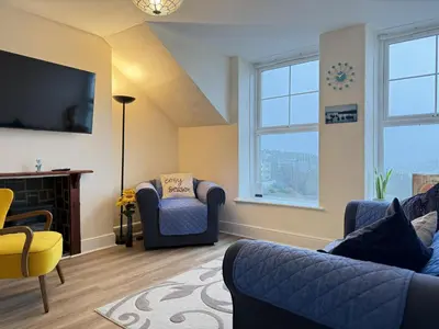 a living room with two chairs and a tv at Draycott Dreams in St Ives