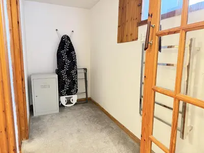 a room with a door and a shelf with a coat at Grannys in St Ives in St Ives