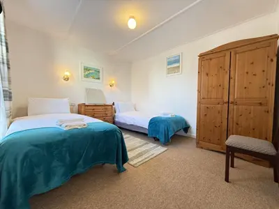 a bedroom with two beds and a cabinet at Grannys in St Ives in St Ives