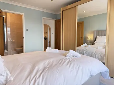 a bedroom with two beds and a large mirror at Seaview Clearwater in St Ives