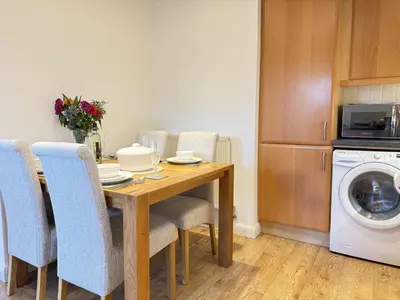 a dining room table with chairs and a washing machine at Seaview Clearwater in St Ives