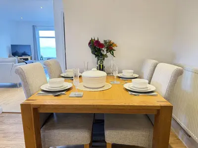 a wooden table with chairs and a dining room at Seaview Clearwater in St Ives