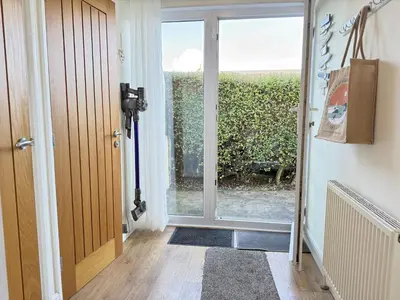 a hallway with a door leading to a patio at Seaview Clearwater in St Ives