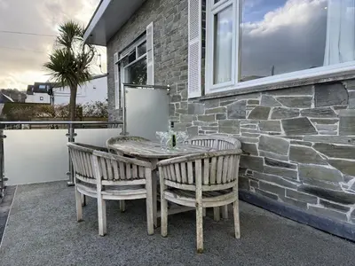 a table and chairs on a patio with a stone wall at Seaview Clearwater in St Ives