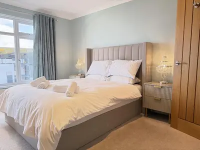 a bedroom with a large bed and a window at Seaview Clearwater in St Ives