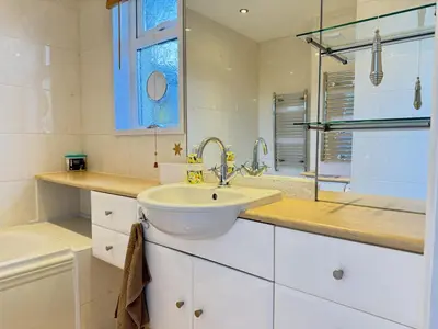 a white bathroom with a sink and a window at Seaview Clearwater in St Ives