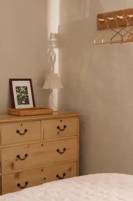 a bedroom with a dresser with a lamp on it at Traditional Cornish Cottage & Garden Redruth in Redruth