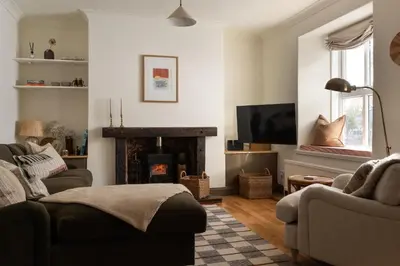 a living room with a couch and a fireplace at Traditional Cornish Cottage & Garden Redruth in Redruth
